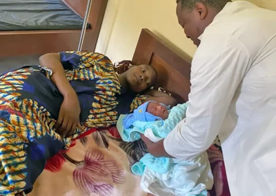 Arzt, Mutter und Baby - Kinderhilfe Nkoumisé-Sud, Kamerun (Foto wurde mit KI-Unterstützung für Print und Web optimiert.)